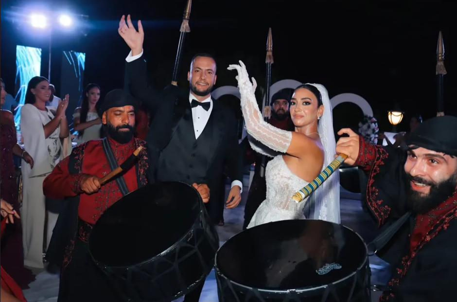 Bride and groom dancing among traditional drummers